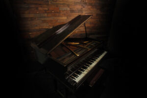 Old baby Grand Piano against wood texture video production studio music video